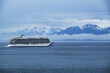 Breathtaking mountain glacier range view with luxury cruiseship cruise ship liner Orion sailing in front of Alaska mountains departure from Hoonah, Icy Strait Point with spectacular landscape scenery