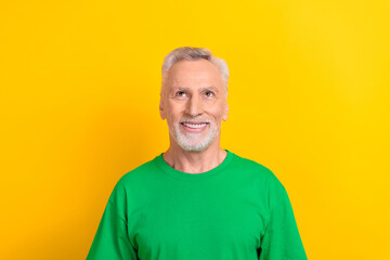 Poster - Photo of cheerful thoughtful man wear green t-shirt looking up empty space isolated yellow color background