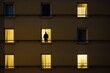 lonely man in backlit window of residential building, loneliness concept and epidemic