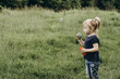 © Анна Молько - blonde girl blowing soap bubbles on the background of green grass. free space for writing