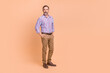 © deagreez - Photo of good mood handsome man with white gray beard wear striped shirt standing arms in pockets isolated on beige color background