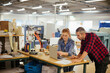 © Geber86 - Young man and young woman using a laptop while working in a printing press office