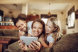 © Geber86 - Young family taking a selfie on the couch in the living room