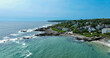 Maine rocky coast with crashing waves and aerial view of marginal way running and walking path.