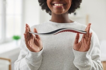 Cropped Shot Of A Happy, Smiling Young African American Woman Holding An Orthotic Orthopedic Arch Support Shoe Insole In Her Hands. Soles, Footwear, Feet Health Concept