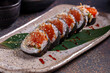 Sushi roll with salmon, eel, avocado, cucumber and sesame seeds