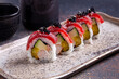 Sushi roll with salmon, cucumber and red caviar.