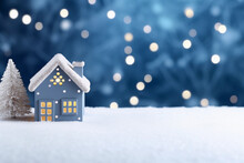 Cute Small Houses Christmas Background With Copyspace. Festive Blue Snowy Background With Christmas Lights, Blurred Background.