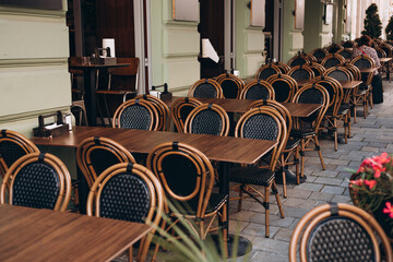 Empty restaurant summer terrace with tables and chairs. Reastaurant tables waiting for customers at an outdoor terrace. Cozy street with tables of cafe in Paris, France.