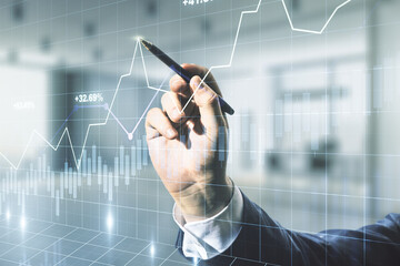 Man hand with pen working with abstract virtual financial graph on blurred office background, financial and trading concept. Multiexposure