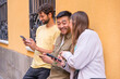 © unai - Group of multiracial friends looking smiling at the phone in the city