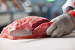 © SuperStock - Detail of butcher slicing through side of beef, behind counter of meat market of grocery store