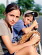  Close up of girl and boy sitting and holding baseball bat, glove and ball 
