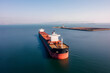 bulk vessel for dry cargo in anchorage in sea waiting loading in industrial port aerial shot