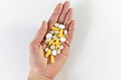 © Natali - Different pills vitamins on the  hand on white table.  Medical, vitamins, health background