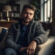 © raquel - Chaming man sitting on the couch in casual clothes looking directly at the camera. Generative AI