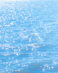 Wall Mural - sun light reflecting or sparkling glitter on water of sea or ocean with beautiful sky blue light ton