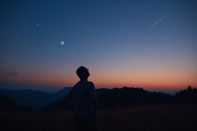 Man Looking At The Starry Skies, Crescent Moon And Shooting Star In Blue Hour Twilight Time.