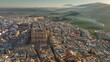 Aerial view of Jaen Cathedral early in the morning. Jaen, Andalucia, Spain with foggy green hills at background. UHD, 4K