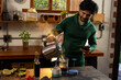 © Wavebreak Media - Indian man making coffee and using smartphone in kitchen at home