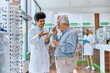 © Drazen - Happy ophthalmologist assisting senior man who is buying eyeglasses in pharmacy.