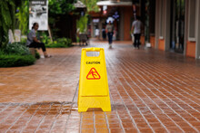 Wet Floor Sign With Water Drops On Wet Stone Floor. Plastic Sign Warning.