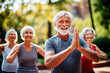 © Creative Clicks - Senior sport enthusiasts exercising during a yoga workout class outdoors at a city park