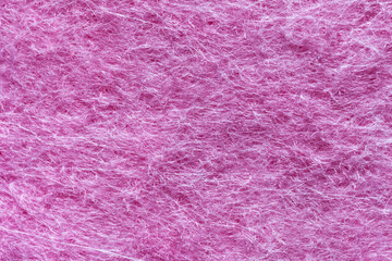 Close-up of fragment of non-woven viscose pink fabric. Textile background from synthetic fibers. Basis for napkins used in the household for washing dishes and cleaning. Flat lay, macro, mockup