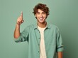 © Tuyres - Portrait of a fictional young guy pointing finger up isolated on a plain colored background. Generative AI.