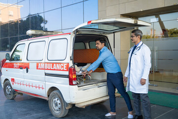 Wall Mural - Doctor receiving old man from ambulance and checking while moaning in pain.