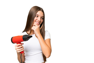 Wall Mural - Teenager Caucasian girl holding a hairdryer over isolated background thinking an idea and looking side