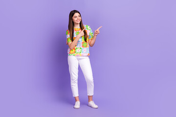 Sticker - Full size photo of cheerful lovely person wear stylish t-shirt indicating look at offer empty space isolated on purple color background