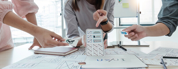 A close-up of an ux ui developer and an ui designer working on a mockup icon interface for a mobile app