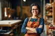 © Goffkein - Portrait of smiling joyful satisfied craftswoman wearing apron and glasses working in her wooden workshop