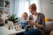 © pixardi - Caucasian mom and toddler video call doctor at home with thermometer. Telemedicine concept. Photo generative AI