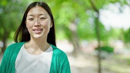 Poster - Young chinese woman smiling confident standing at park