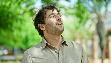 Poster - Young hispanic man smiling confident breathing at park