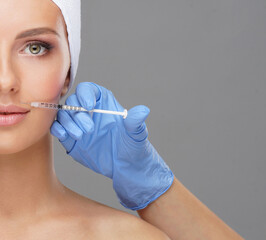 Wall Mural - Doctor injecting in a beautiful face of a young woman. Plastic surgery concept.