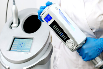 Close-up of a cosmetologist holding a lymphatic drainage massager for weight loss in a beauty clinic. A doctor using an endospheric therapy device for a client