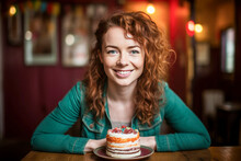 25 Year Old Woman With Red Hair Posing In Front Of A Small Birthday Cake.