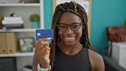 Wall Mural - African american woman business worker holding credit card smiling at the office