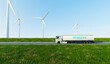 Hydrogen fuel transportation and storage, green power and zero emissions energy, big truck with hydrogen storage transfer with wind turbines or wind mill, 3d illustrations rendering