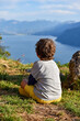 Child seen from behind contemplating from an elevated viewpoint the Lake Bourget (