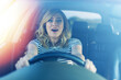 © Denis Rozhnovsky - Frightened woman driving a car. A woman drives a car on the road.