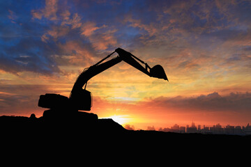 Crawler excavators silhouette are digging the soil in the construction site. on the sky  and  sunset background