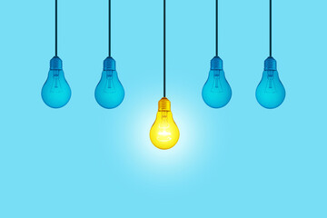 Wall Mural - Blue light bulbs with glowing one yellow different light bulb idea hanging on blue background.  Think creatively concept. New Creative Idea. Brainstorm