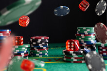 Online gaming business, casino, poker. Flying, levitating chips against the background of a poker table, money and chips. Creative light. Background for the casino gaming business.