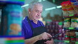 © Marco - Brazilian older manager of Grocery Store walking through supermarket aisle inspecting inventory. South American job occupation, local business
