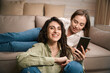 © Svitlana - Two smiling females having fun using phone