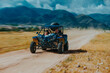 Father and son driving fast buggy on mountain road, blurred motion